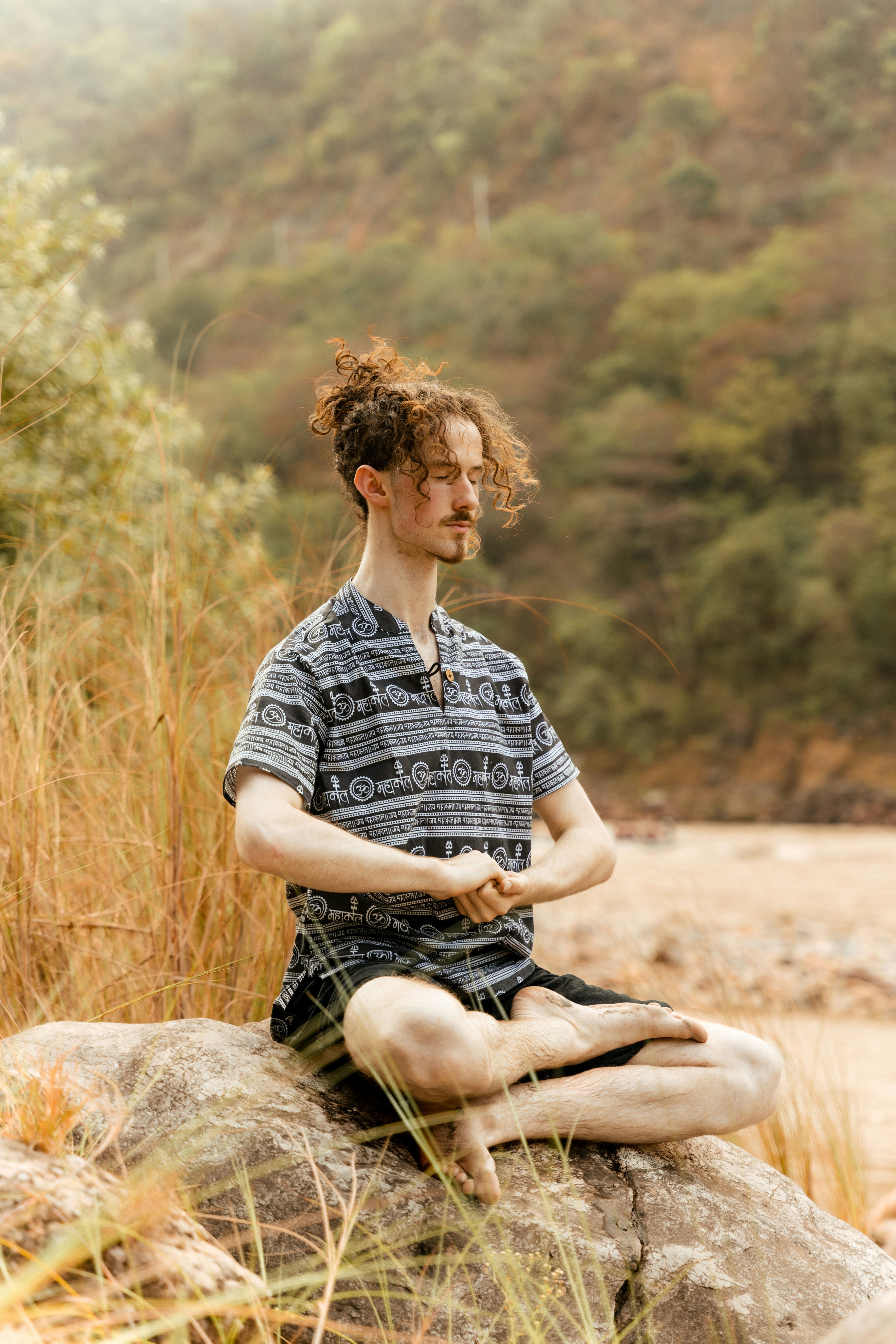 a man sitting on a rock doing yoga